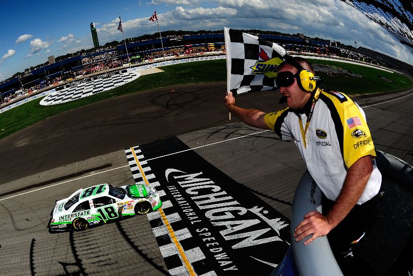Kyle Busch, driver of the No. 18 Interstate Batteries Toyota, takes the checkered flag as he crosses the finish line to win the NASCAR Sprint Cup Series Pure Michigan 400 at Michigan International Speedway on Aug. 21 in Brooklyn, Mich. Credit: Jared C. Tilton/Getty Images for NASCAR